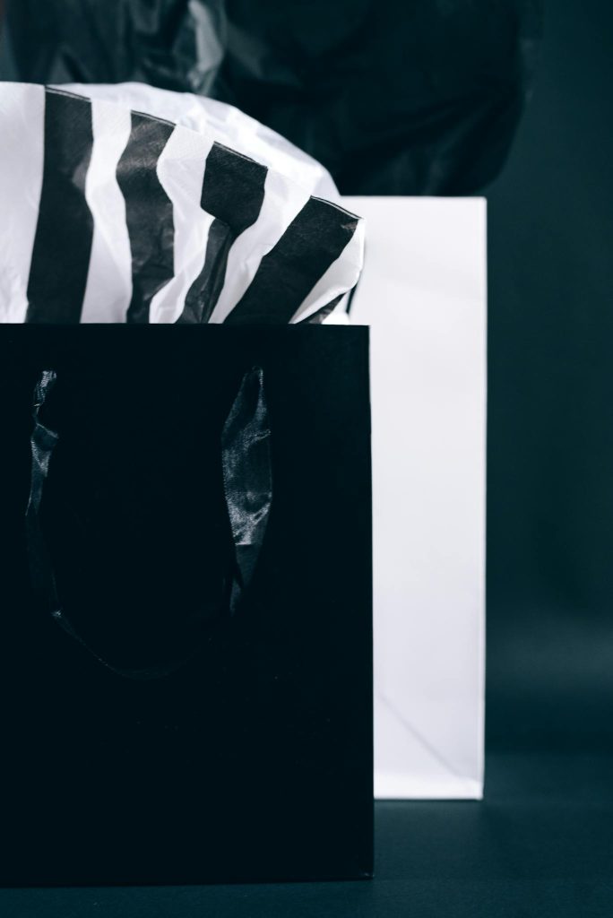 Modern black and white shopping bags with tissue paper, perfect for Black Friday promotions.