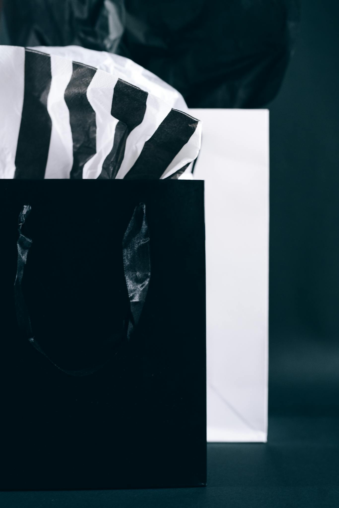 Modern black and white shopping bags with tissue paper, perfect for Black Friday promotions.