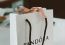 White Pandora shopping bag with elegant handles on a desk.